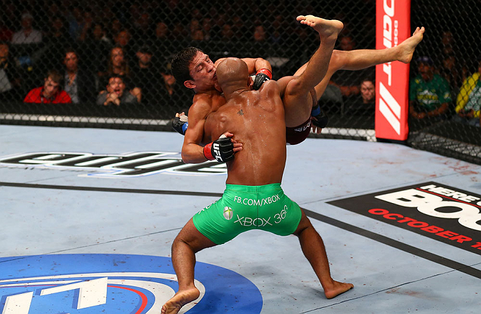 TORONTO, CANADA - SEPTEMBER 22: Demetrious Johnson (green shorts) takes down Joseph Benavidez during their flyweight championship bout at UFC 152 inside Air Canada Centre on September 22, 2012 in Toronto, Ontario, Canada. (Photo by Al Bello/Zuffa LLC/Zuffa LLC via Getty Images)