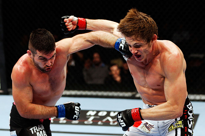 MONTREAL, QC - NOVEMBER 17:  John Maguire (L) and Matthew Riddle throw punches at each other in their welterweight bout during UFC 154 on November 17, 2012  at the Bell Centre in Montreal, Canada.  (Photo by Josh Hedges/Zuffa LLC/Zuffa LLC via Getty Images)