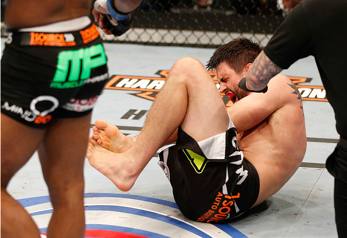 DALLAS, TX - MARCH 15:  Carlos Condit lays on the mat in pain after suffering a knee injury against Tyron Woodley in their welterweight bout at UFC 171 inside American Airlines Center on March 15, 2014 in Dallas, Texas. (Photo by Josh Hedges/Zuffa LLC/Zuffa LLC via Getty Images)