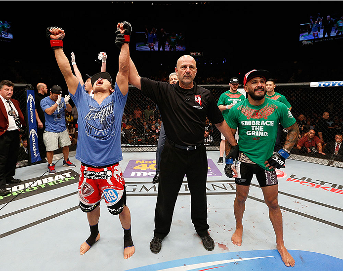 LAS VEGAS, NV - MAY 24:  Takeya Mizugaki (left) reacts to his victory over Francisco Rivera (right) in their bantamweight bout during the UFC 173 event at the MGM Grand Garden Arena on May 24, 2014 in Las Vegas, Nevada. (Photo by Josh Hedges/Zuffa LLC/Zuffa LLC via Getty Images)