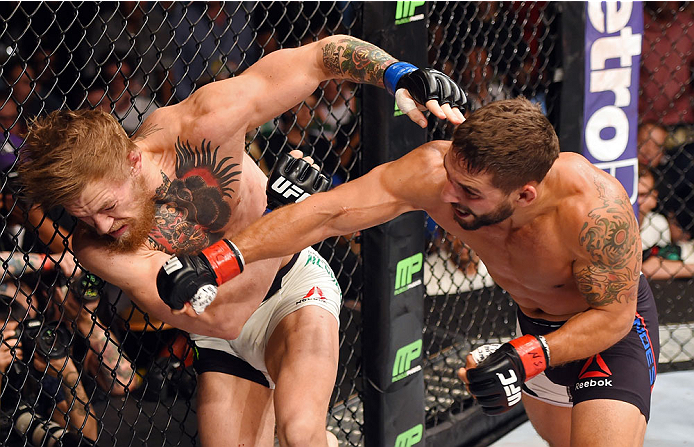 Chad Mendes punches Conor McGregor in their UFC interim featherweight title fight during the UFC 189 event inside MGM Grand Garden Arena on July 11, 2015 in Las Vegas, Nevada. (Photo by Josh Hedges/Zuffa LLC)