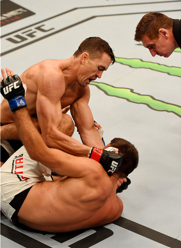 Kyle Noke (L) punches Peter Sobotta (C) in round one of their welterweight bout during the UFC 193 event at Etihad Stadium on November 15, 2015 in Melbourne, Australia. (Photo by Josh Hedges)