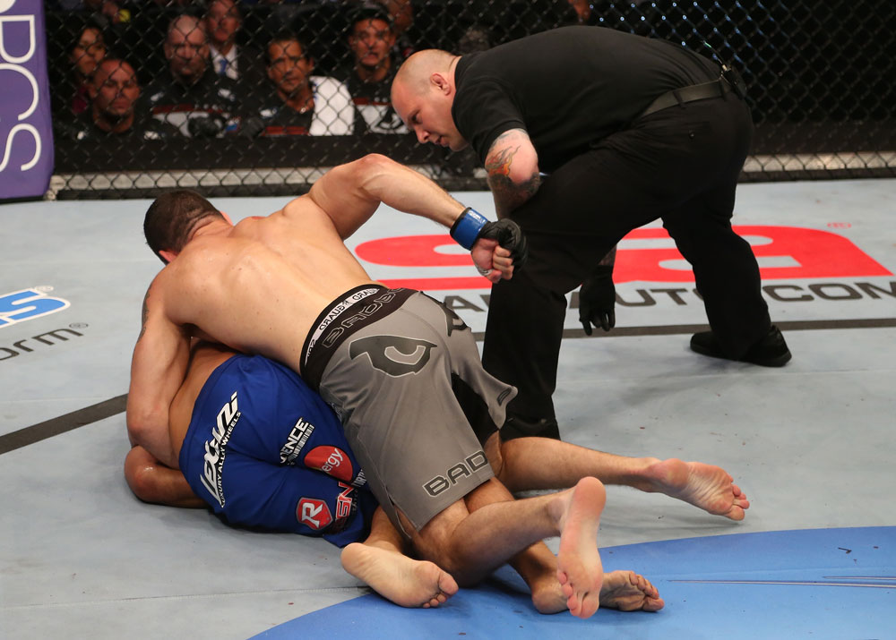 SAN JOSE, CA - JULY 11: Chris Weidman (grey shorts) punches Mark Munoz (blue shorts) as referee Josh Rosenthal during their middleweight bout at HP Pavilion on July 11, 2012 in San Jose, California. (Photo by Ezra Shaw/Zuffa LLC/Zuffa LLC via Getty Images) *** Local Caption *** Mark Munoz; Chris Weidman; Josh Rosenthal