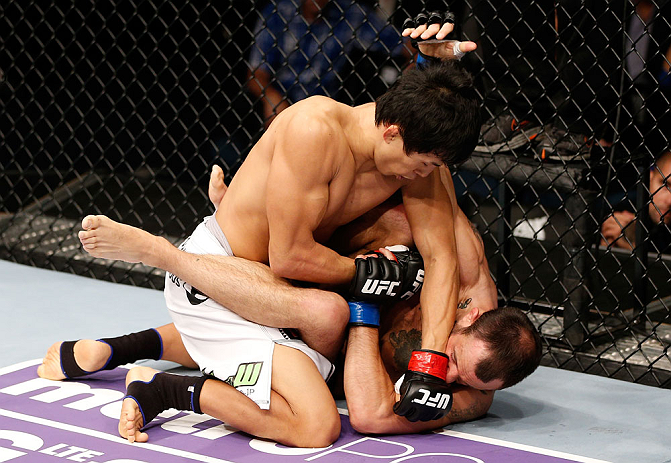 MACAU, MACAU - NOVEMBER 10:  (L-R) Takeya Mizugaki punches Jeff Hougland during their bantamweight bout at the UFC Macao event inside CotaiArena on November 10, 2012 in Macau, Macau.  (Photo by Josh Hedges/Zuffa LLC/Zuffa LLC via Getty Images)