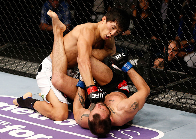 MACAU, MACAU - NOVEMBER 10:  (L-R) Takeya Mizugaki punches Jeff Hougland during their bantamweight bout at the UFC Macao event inside CotaiArena on November 10, 2012 in Macau, Macau.  (Photo by Josh Hedges/Zuffa LLC/Zuffa LLC via Getty Images)