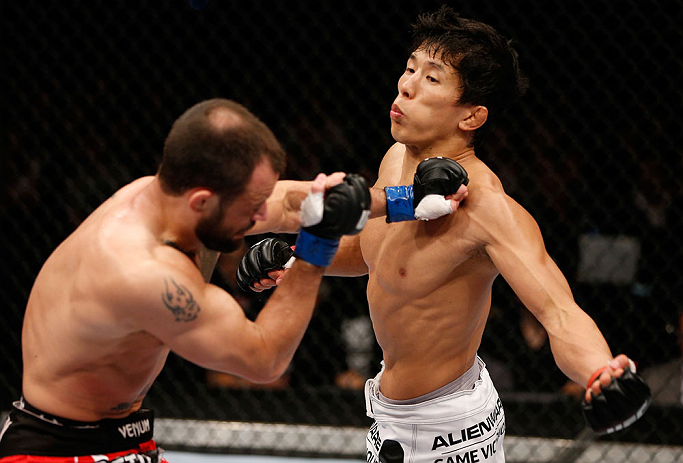 MACAU, MACAU - NOVEMBER 10:  (R-L) Takeya Mizugaki punches Jeff Hougland during their bantamweight bout at the UFC Macao event inside CotaiArena on November 10, 2012 in Macau, Macau.  (Photo by Josh Hedges/Zuffa LLC/Zuffa LLC via Getty Images)