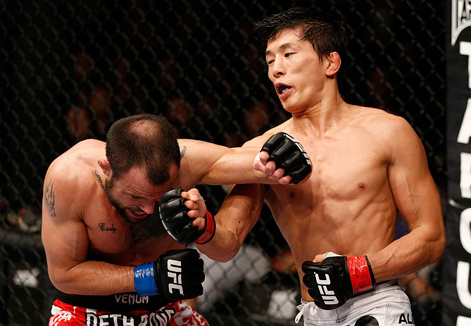MACAU, MACAU - NOVEMBER 10:  (R-L) Takeya Mizugaki punches Jeff Hougland during their bantamweight bout at the UFC Macao event inside CotaiArena on November 10, 2012 in Macau, Macau.  (Photo by Josh Hedges/Zuffa LLC/Zuffa LLC via Getty Images)
