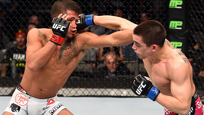 (R-L) Ryan Benoit lands a punch to the face of Sergio Pettis in their flyweight bout during the UFC 185 event at the American Airlines Center on March 14, 2015 in Dallas, Texas. (Photo by Josh Hedges/Zuffa LLC)